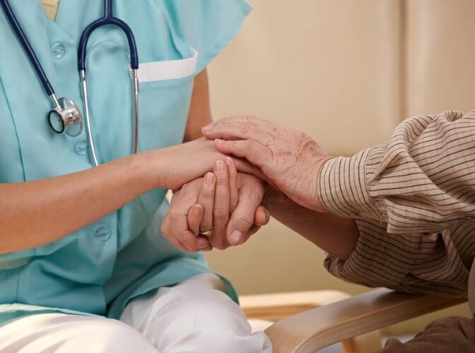 Nurse and patient holding hands