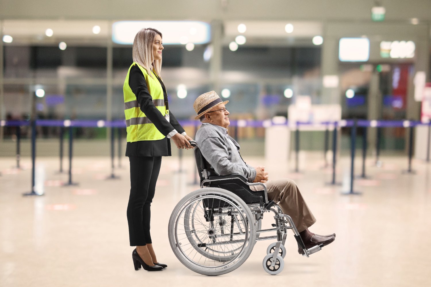 Airport assistant helping an older man in a wheelchair